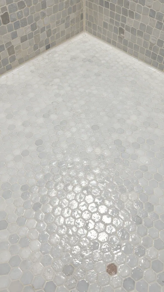 small hex mosaic shower floor, wet textured closeup